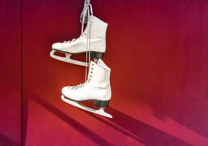hanged pair of white leather figure skates